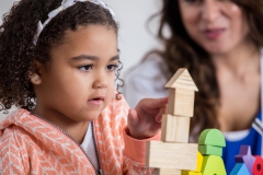 Girl builds with wooden blocks